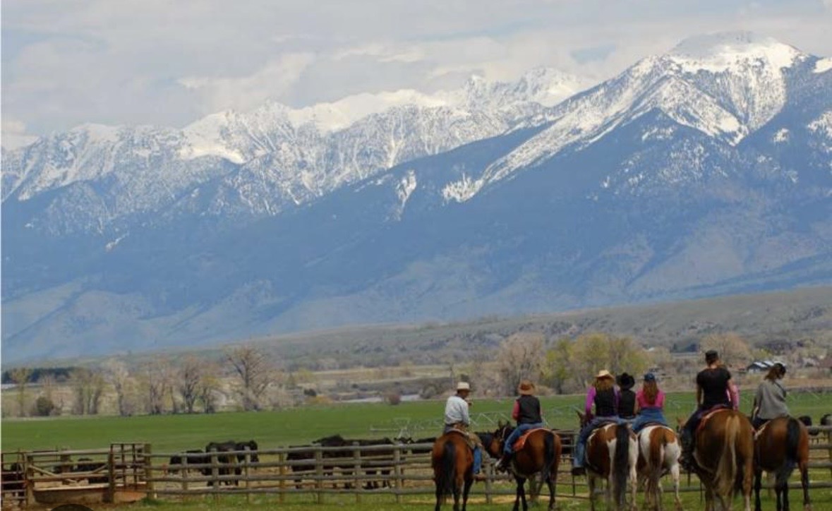 Guest overlooking turquoise mountain lake at Aspen Falls Ranch